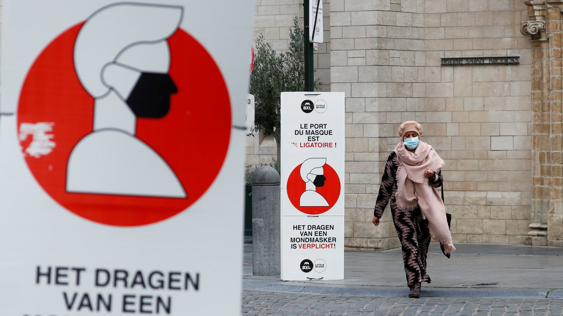 A woman walks past a sign announcing the mandatory use of masks in central Brussels as Belgian government meets to announce new restrictive measures after a spike of coronavirus disease (COVID-19) infections, Belgium October 16, 2020.