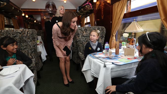 Catherine, Duchess of Cambridge, commonly known as Kate Middleton, greets children aboard the Belmond British Pullman train.