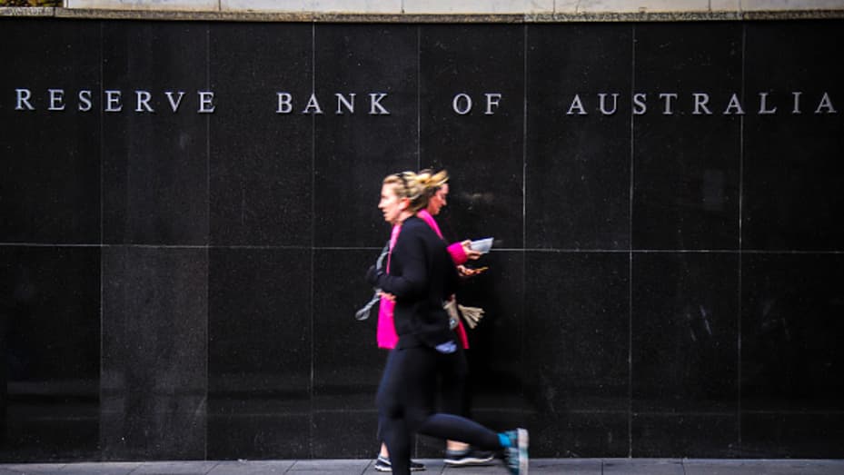 Un peatón y un corredor pasan por el edificio del Banco de la Reserva de Australia (RBA), durante un bloqueo parcial impuesto debido al coronavirus, en Sydney, Australia, el lunes 18 de mayo de 2020.