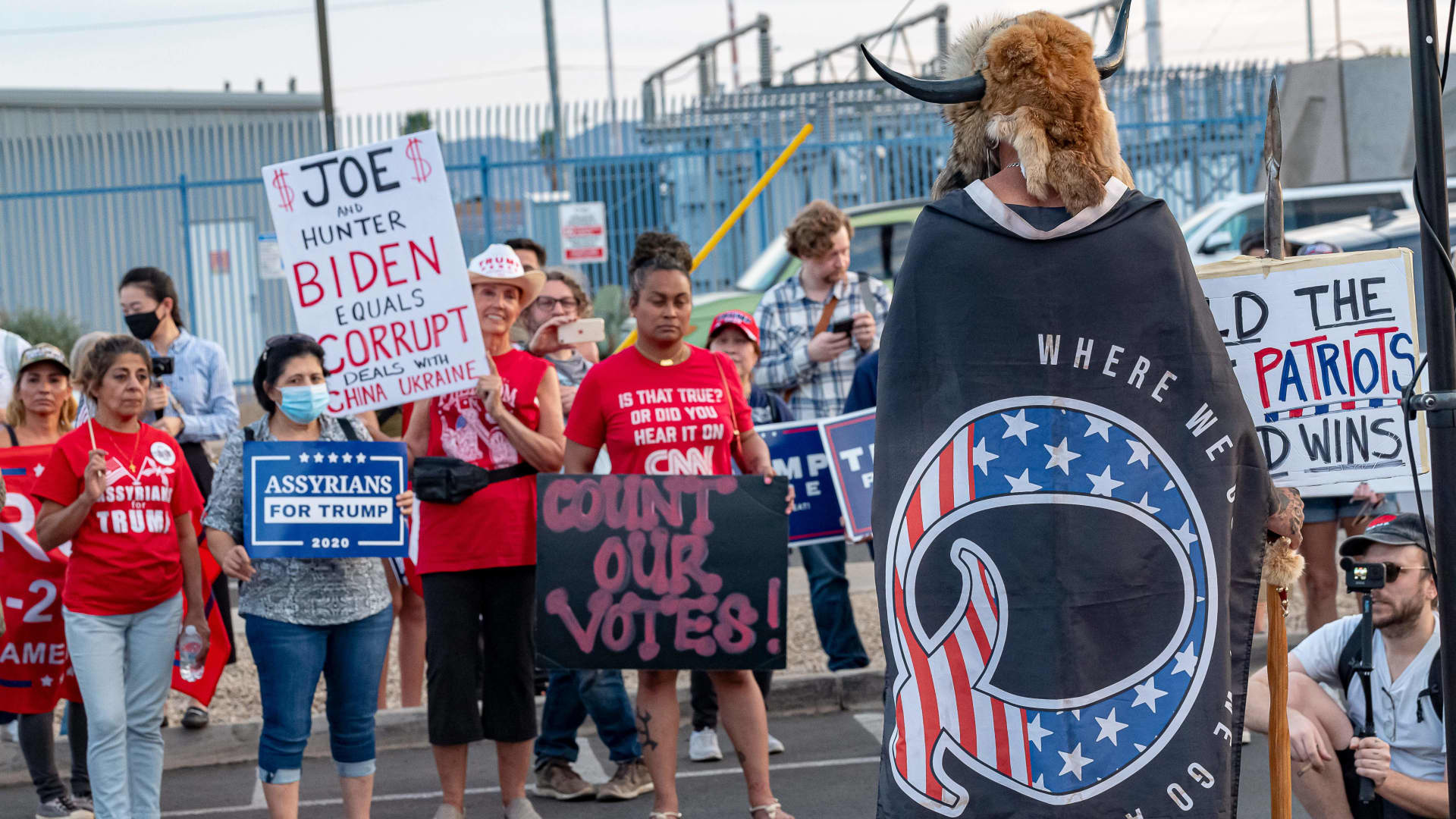 Jake A, 33, aka Yellowstone Wolf, from Phoenix, wrapped in a QAnon flag, addresses supporters of US President Donald Trump as they protest outside the Maricopa County Election Department as counting continues after the US presidential election in Phoenix, Arizona, on November 5, 2020.