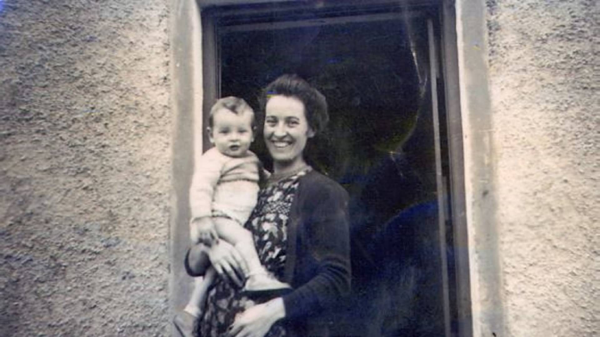 Michael Dowling as a baby, being held by his mother, Meg, in front of their thatched cottage home in Knockaderry, a small village in County Limerick, Ireland.