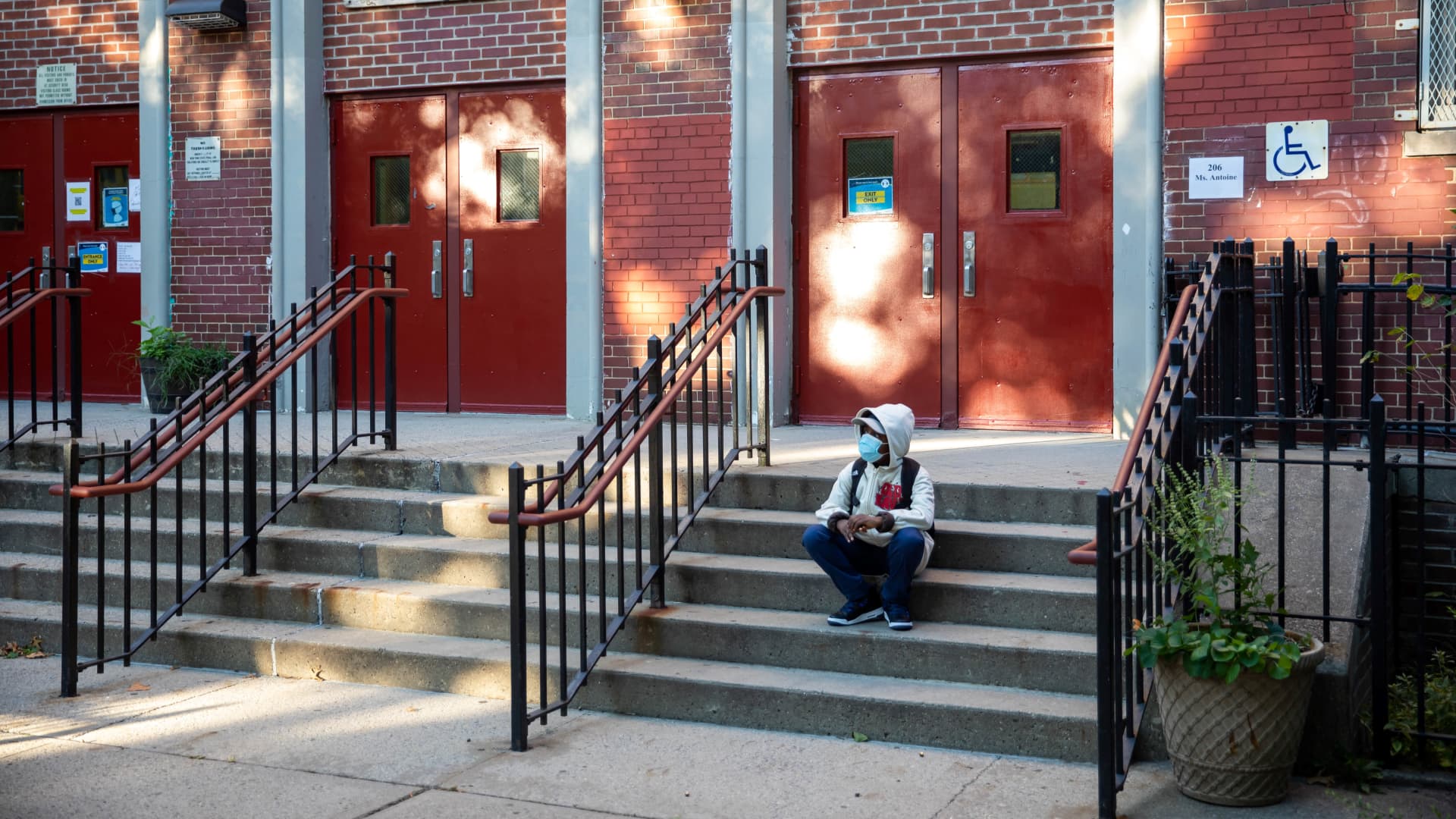 A student is seen on the steps of the closed public school PS 139 in the Ditmas Park neighborhood in Brooklyn of New York, the United States, Oct. 8, 2020.