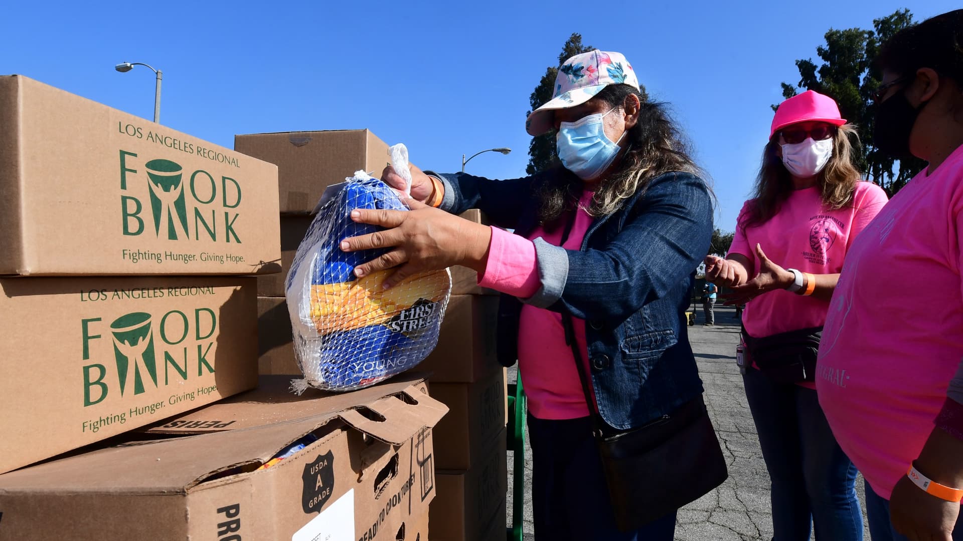 Volunteers from women's organization Nuevo Amanecer Mujer Integral help with the distribution of frozen turkeys and food boxes ahead of Thanksgiving to families affected by the Covid-19 pandemic on November 18, 2020 in Los Angeles, California.