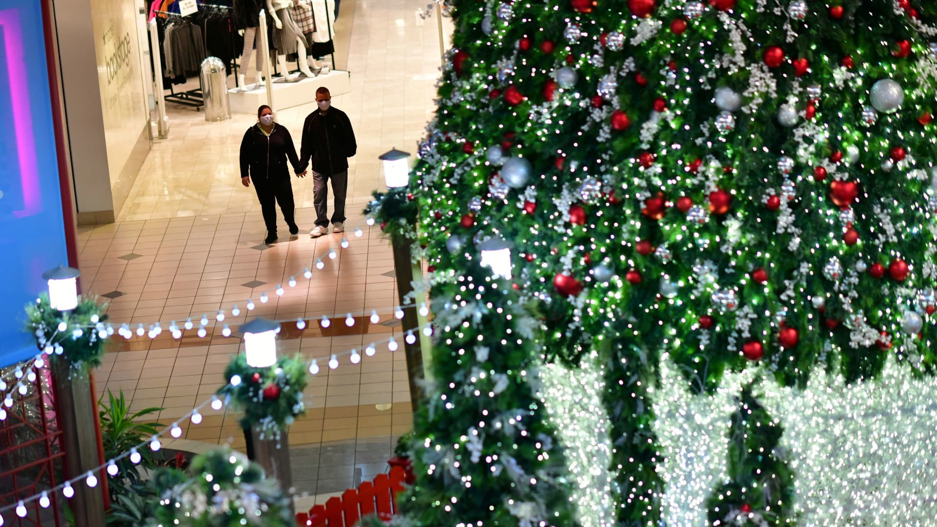 Shoppers hold hands at the Willow Grove Park Mall in Willow Grove, Pennsylvania, November 14, 2020.