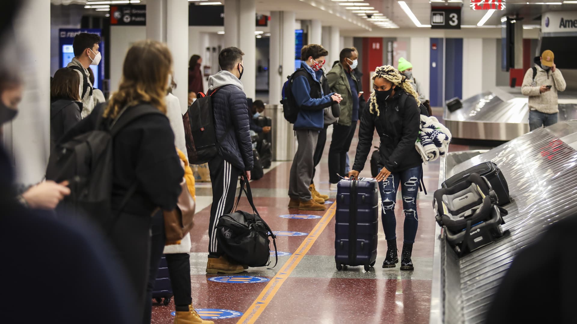 People wait for their baggage in the terminal at Boston Logan International Airport in Boston on Nov. 25, 2020.