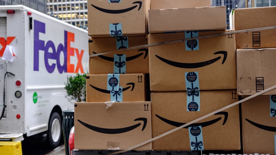 Amazon.com Inc. packages sit in front of a FedEx Corp. delivery truck in New York.