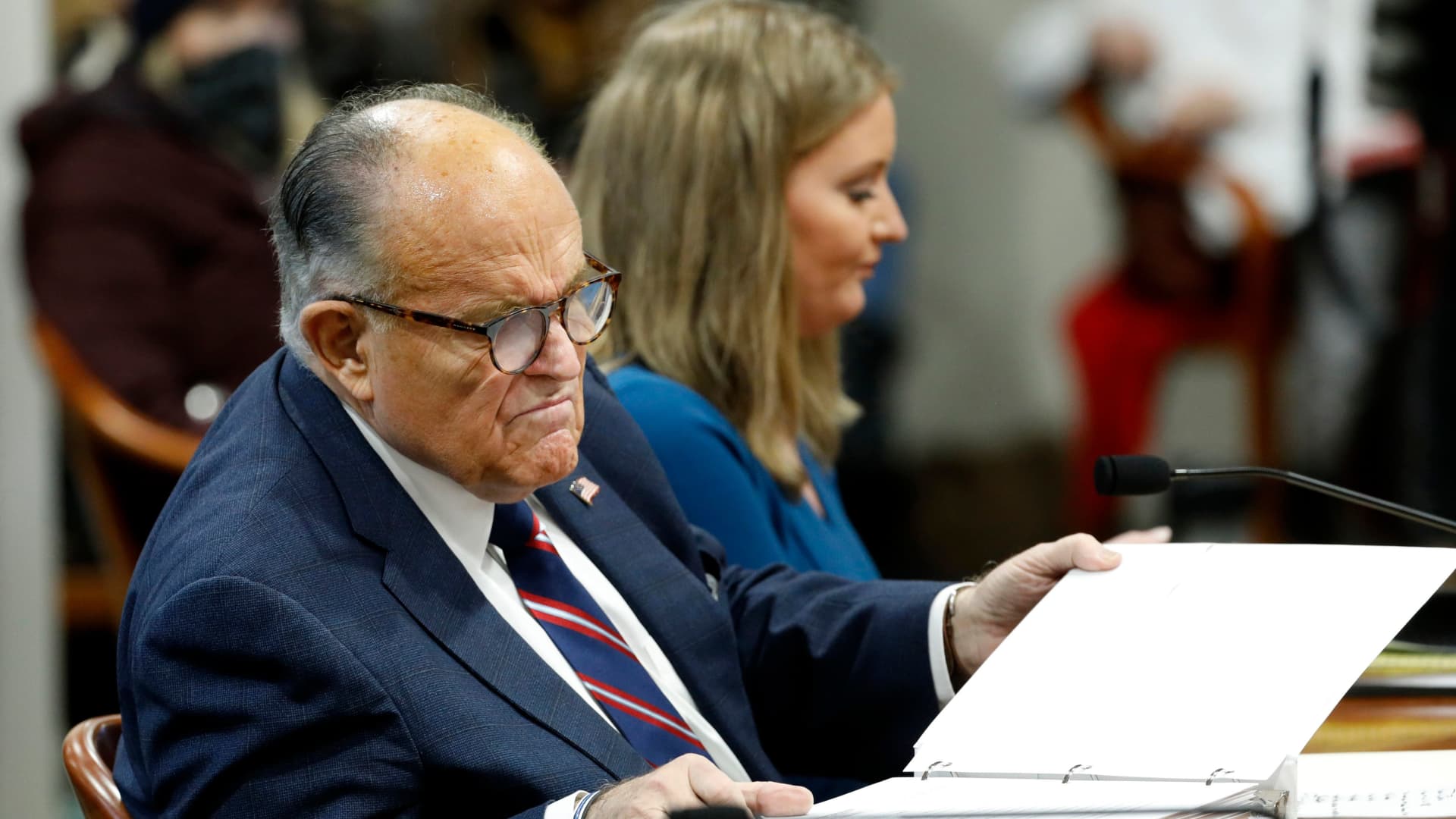 Rudy Giuliani, personal lawyer of US President Donald Trump, looks at documents as he appears before the Michigan House Oversight Committee in Lansing, Michigan on December 2, 2020.