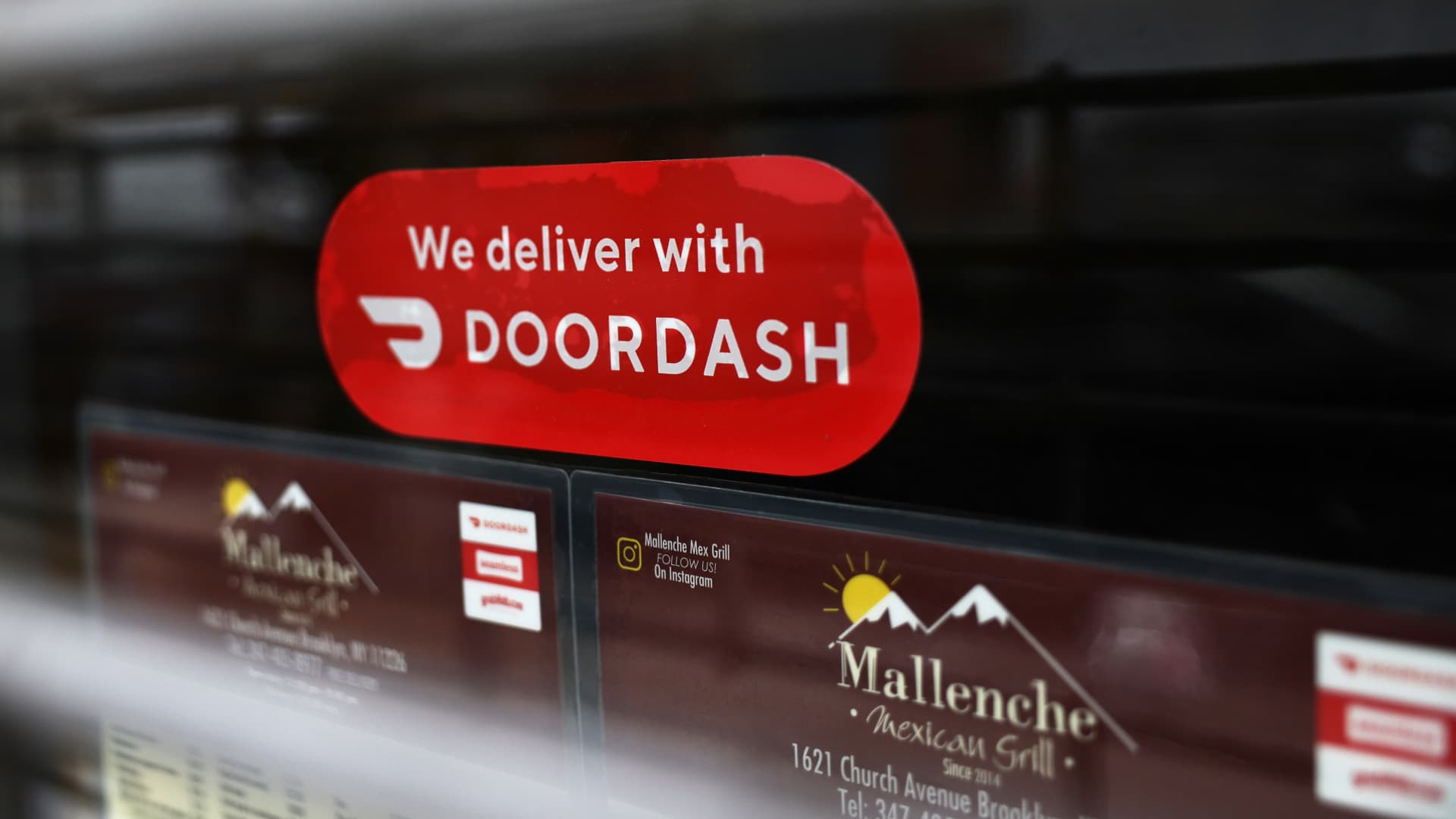 A Doordash sticker is seen on a window at Mallenche Mexican Grill in the Flatbush neighborhood of Brooklyn on December 04, 2020 in New York City. Food delivery startup DoorDash Inc is expected to raise its U.S. initial public offering up to $3.14 billion.
