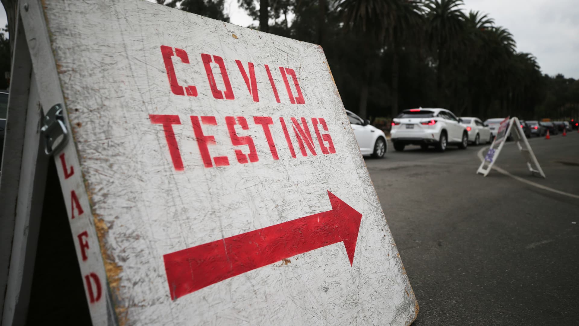 Vehicles line up to enter a COVID-19 testing site at Dodger Stadium on the first day of new stay-at-home orders on December 7, 2020 in Los Angeles, California.