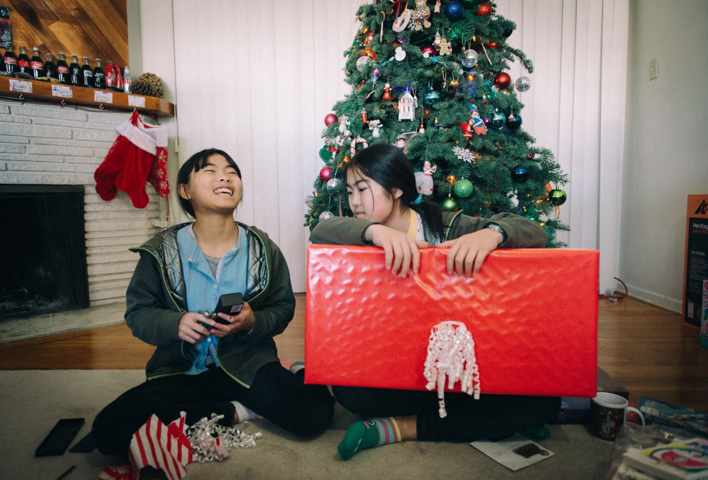 Two kids opening presents at Christmas