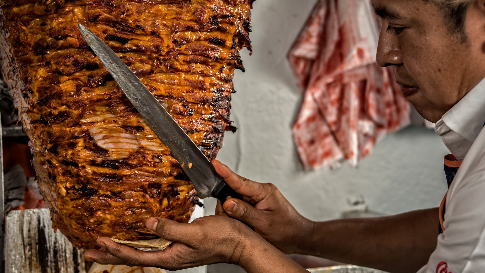 Marinated pork is sliced to prepare a plate of tacos al pastor at El Tizoncito restaurant in Mexico City.