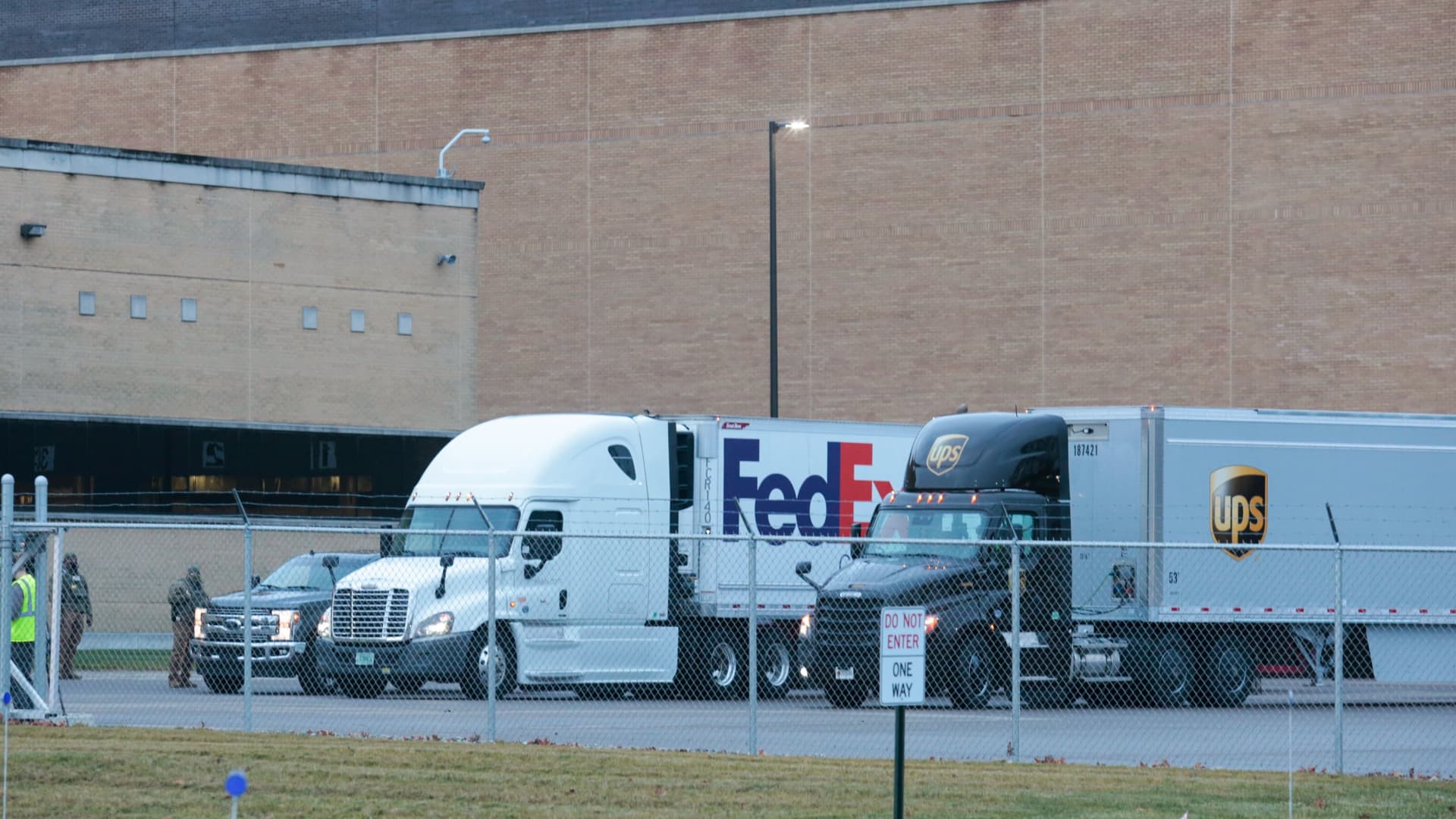 FedEx and UPS trucks leave the loading dock of the Pfizer Global Supply manufacturing plant, in Portage, Michigan, U.S., December 13, 2020.