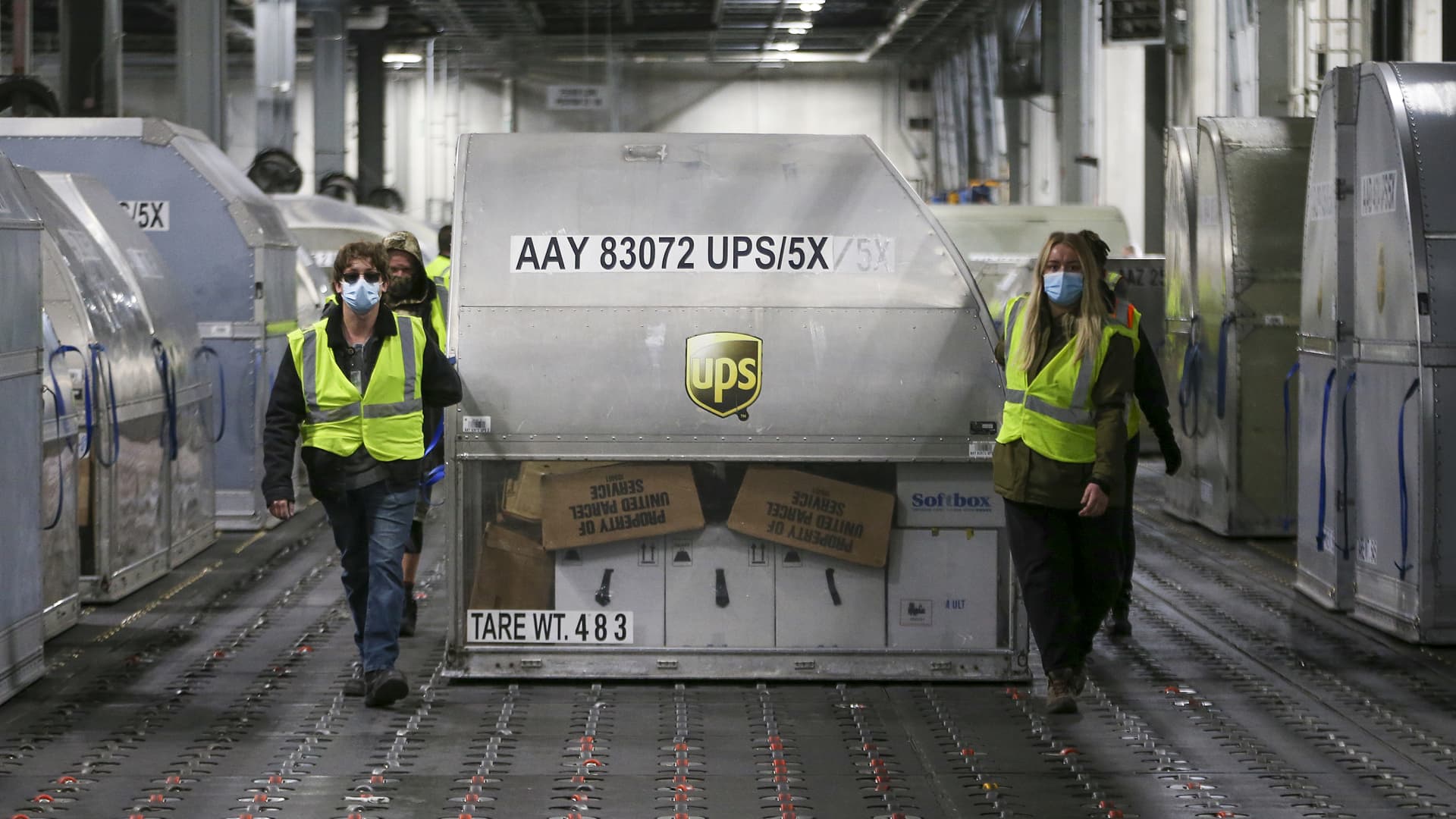 UPS employees move one of two shipping containers containing the first shipments of the Pfizer and BioNTech Covid vaccine inside a sorting facility at UPS Worldport on December 13, 2020 in Louisville, Kentucky.