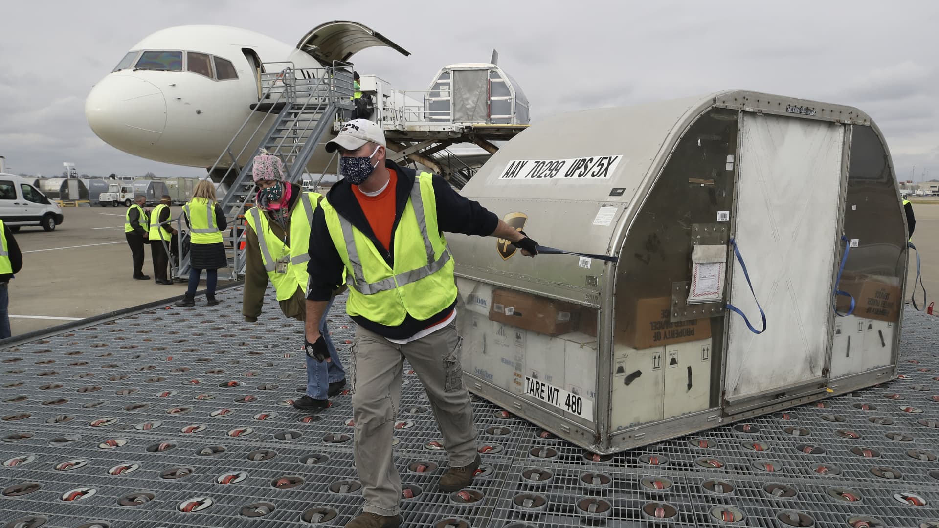 UPS employees move one of two shipping containers containing the first shipments of the Pfizer and BioNTech COVID-19 vaccine on a ramp at UPS Worldport in Louisville, Kentucky, on Sunday, December 13, 2020.