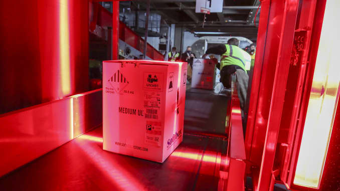 Boxes containing the first shipments of the Pfizer and BioNTech COVID-19 vaccine are unloaded from air shipping containers and scanned at UPS Worldport on December 13, in Louisville, Kentucky.