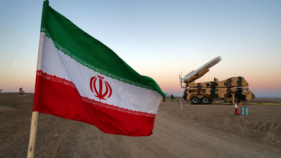 Una bandera iraní aparece cerca de un misil durante un simulacro militar, con la participación de unidades de defensa aérea de Irán, Irán, el 19 de octubre de 2020.