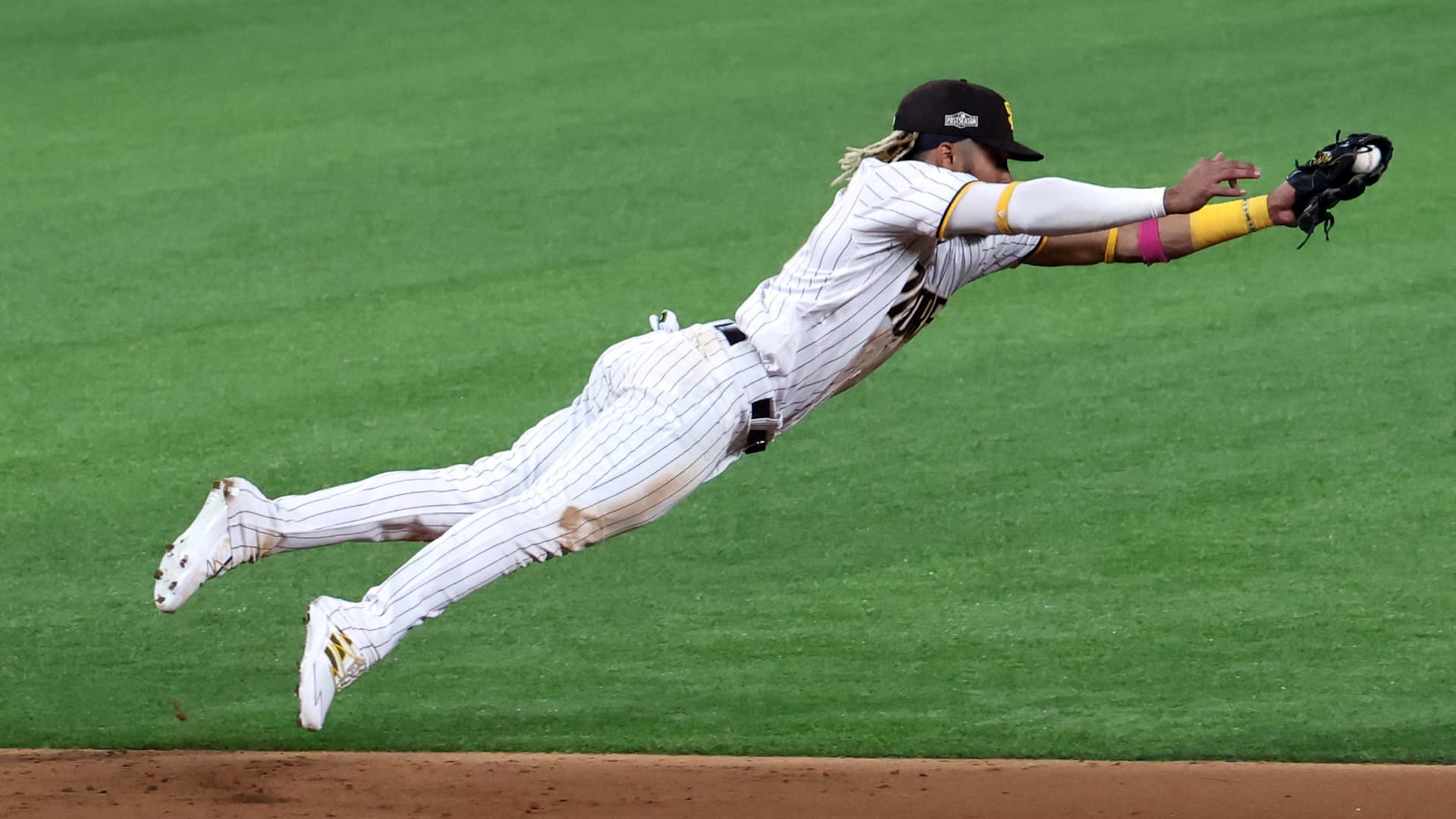 Fernando Tatis Jr. #23 of the San Diego Padres dives to cut off a ball hit by Corey Seager #5 of the Los Angeles Dodgers (not pictured) during the third inning in Game Three of the National League Division Series at Globe Life Field on October 08, 2020 in Arlington, Texas.