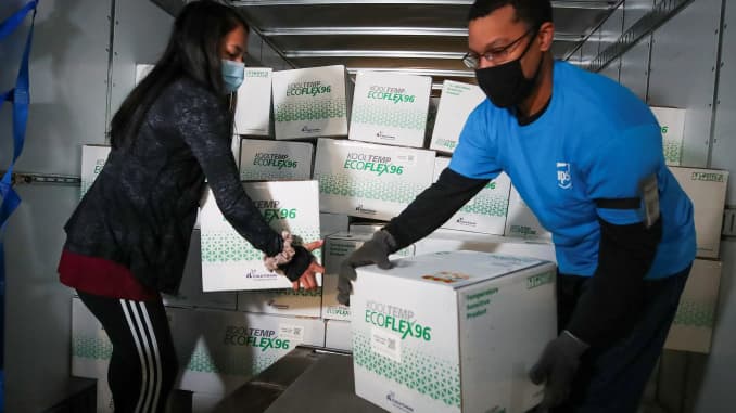 UPS package handlers Jesirae Elzey and Demeatres Ralston unload boxes of Moderna's COVID-19 vaccine as it arrives at UPS Worldport, in Louisville, Kentucky, December 20, 2020.