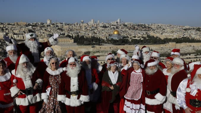 A group people dressed as Santa Claus visit the Mount of Olives overlooking Jerusalem's Old City on Jan. 7, 2020.