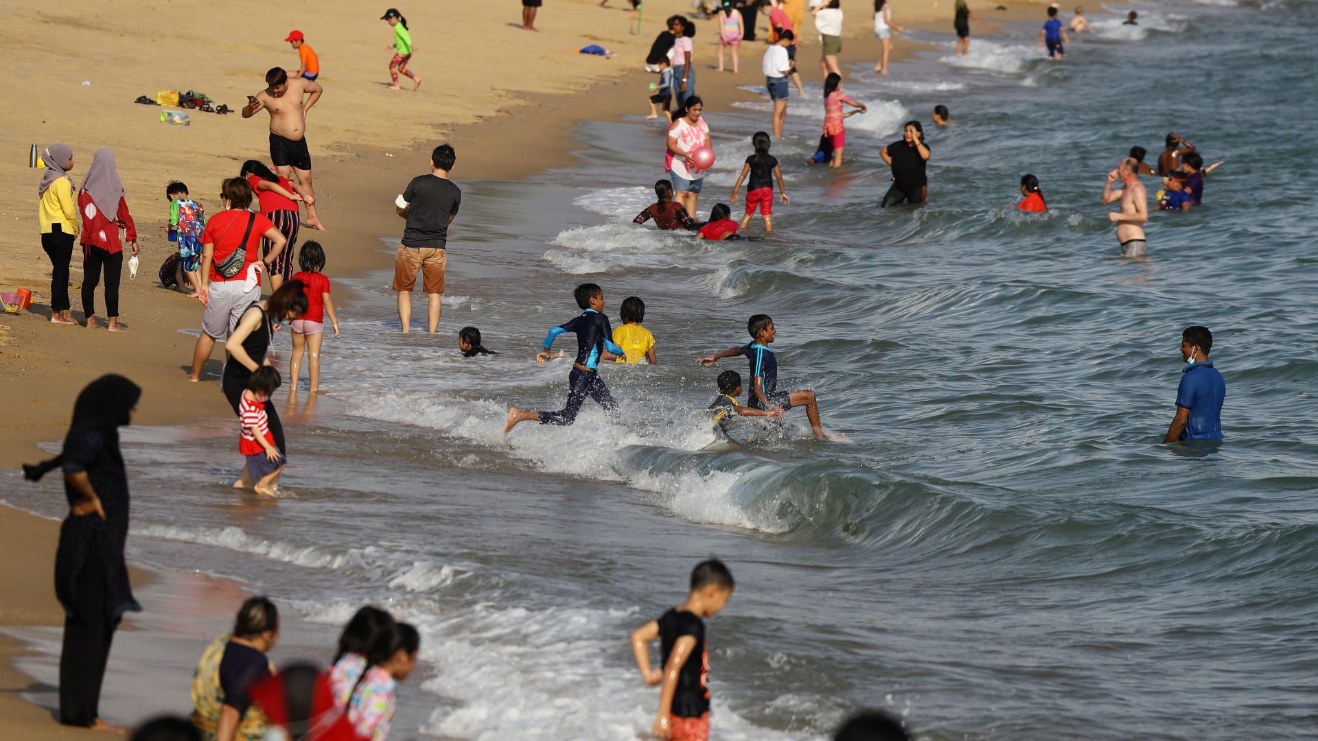 People swim at a beach at East Coast Park on December 25, 2020 in Singapore.