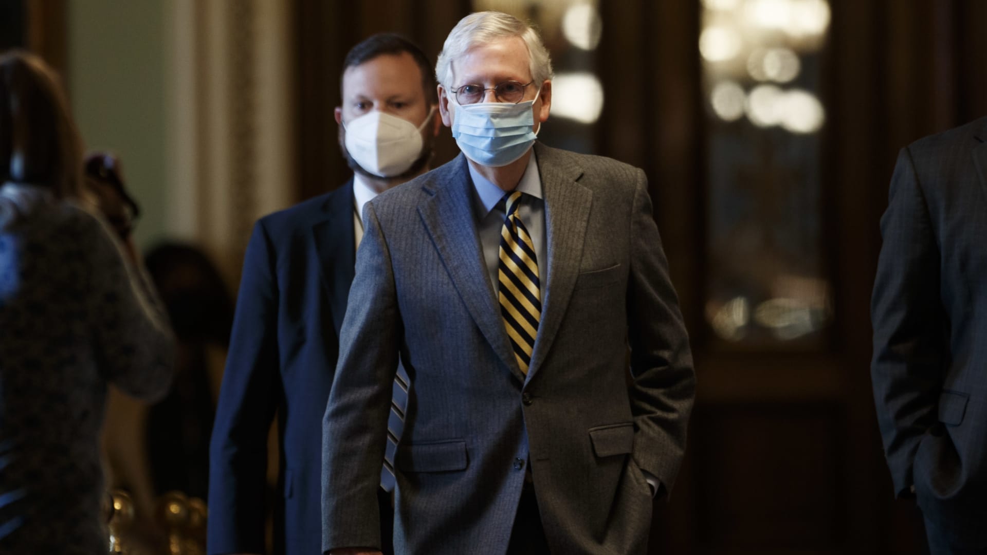 Senate Majority Leader Mitch McConnell, a Republican from Kentucky, center, wears a protective mask while walking through the U.S. Capitol in Washington, D.C., U.S. on Wednesday, Dec. 30, 2020.