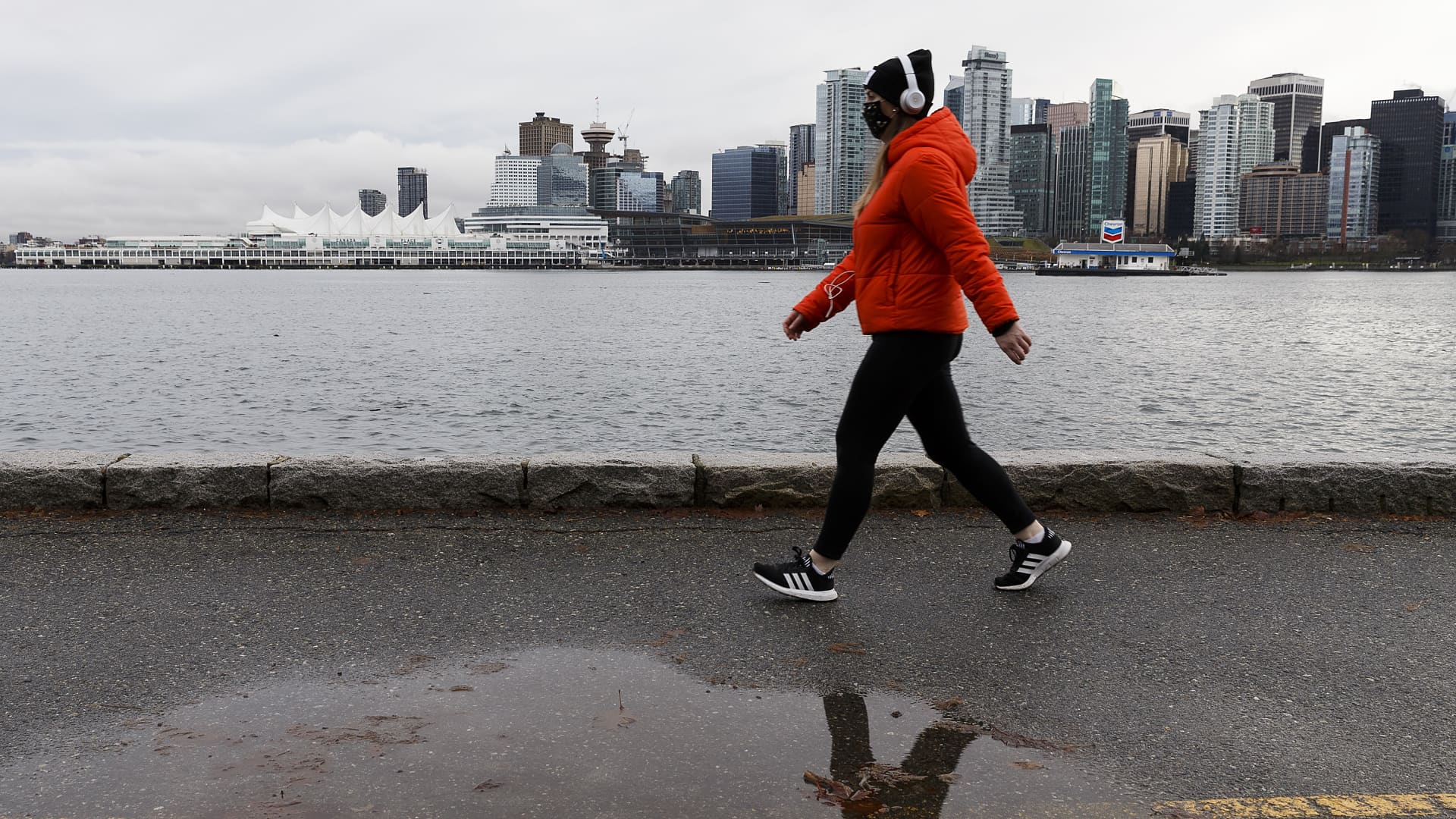 A woman wearing a protective face mask walks on the seawall at Stanley Park on January 04, 2021 in Vancouver, Canada.