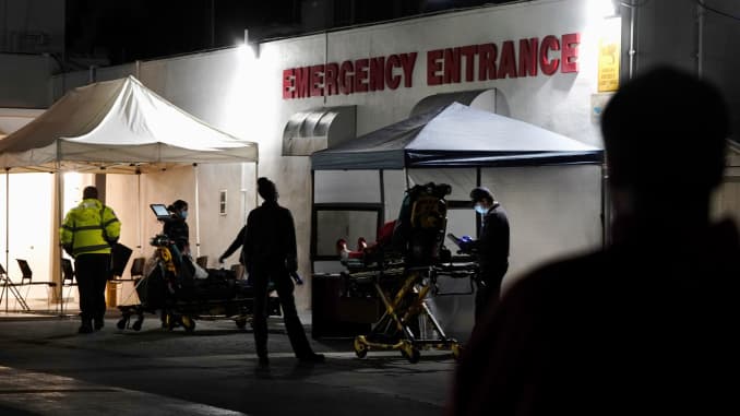 Emergency medical technicians (EMTs) and healthcare workers treat patients outside the emergency room at the Community Hospital of Huntington Park during a surge in positive coronavirus disease (COVID-19) cases in Huntington Park, California, December 29,