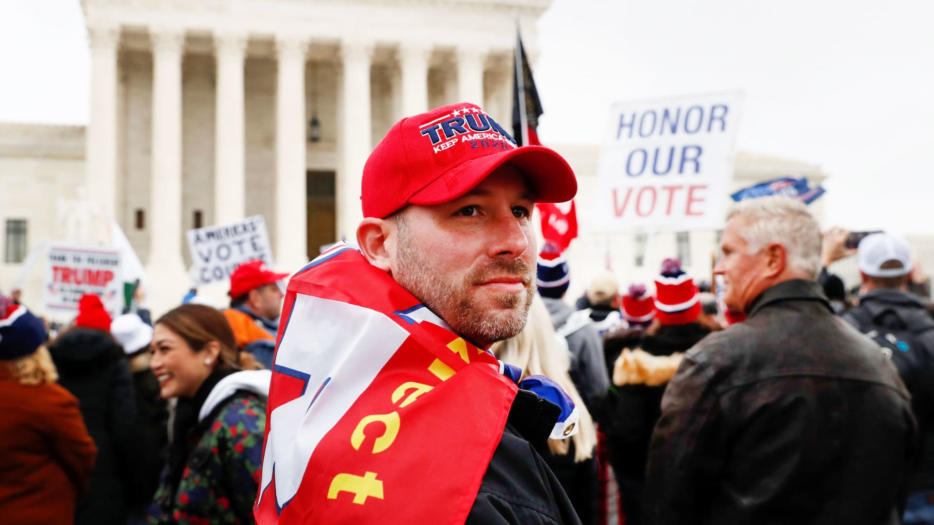 A supporter of U.S. President Donald Trump looks on as others gather in front of the Supreme Court building ahead of the U.S. Congress certification of the November 2020 election results during protests in Washington, January 5, 2021.