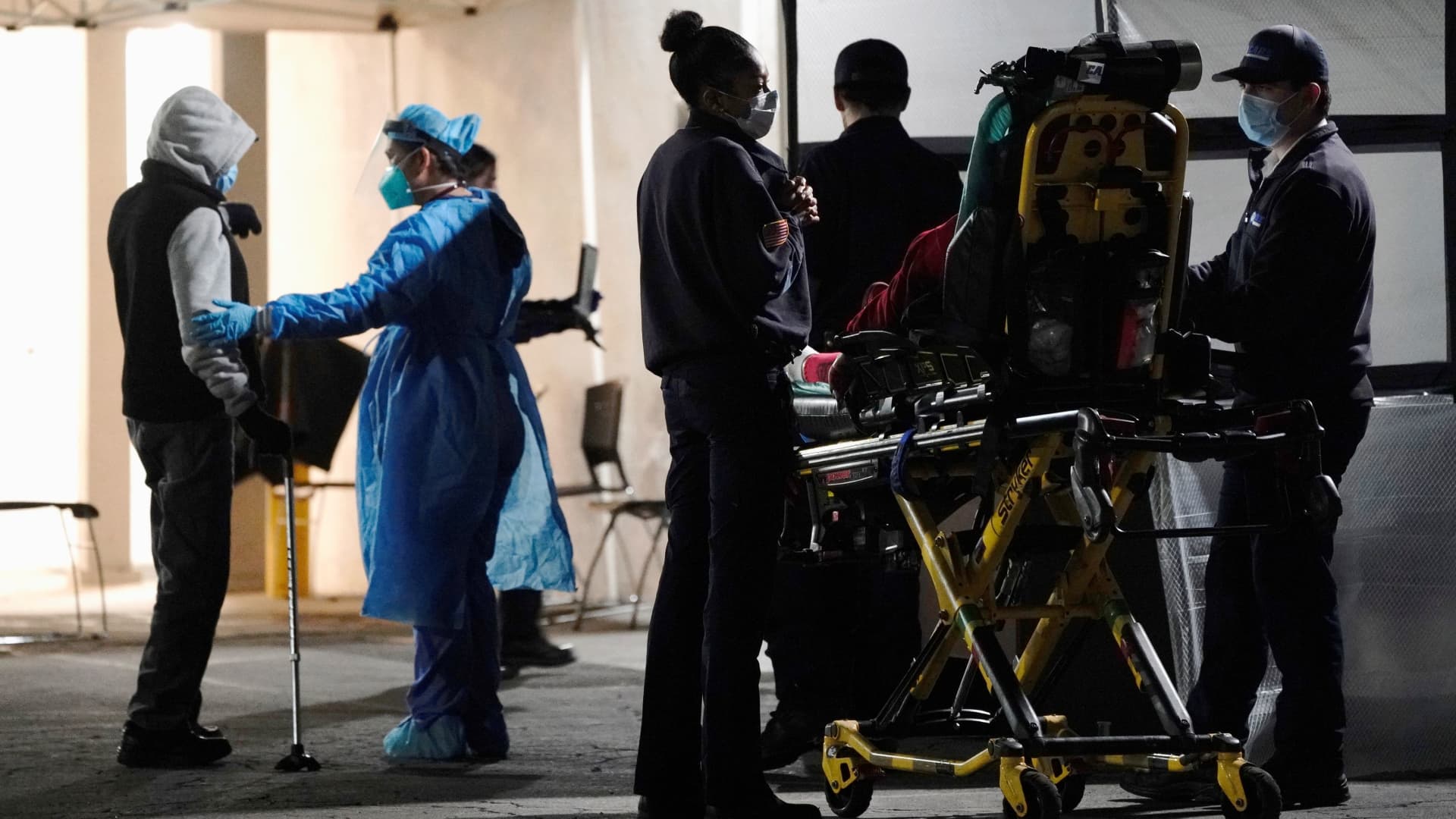 Emergency medical technicians (EMTs) and healthcare workers treat patients outside the emergency room at the Community Hospital of Huntington Park during a surge in positive coronavirus disease (COVID-19) cases in Huntington Park, California, December 29, 2020.