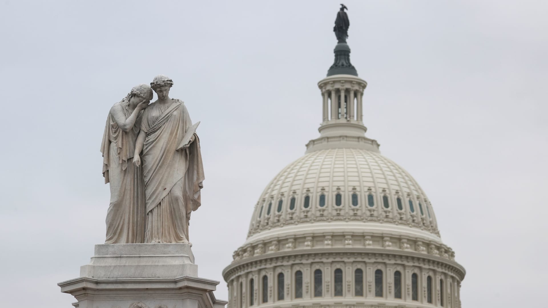 The statue of Grief and History at the Peace Monument is seen in front of the U.S. Capitol dome.