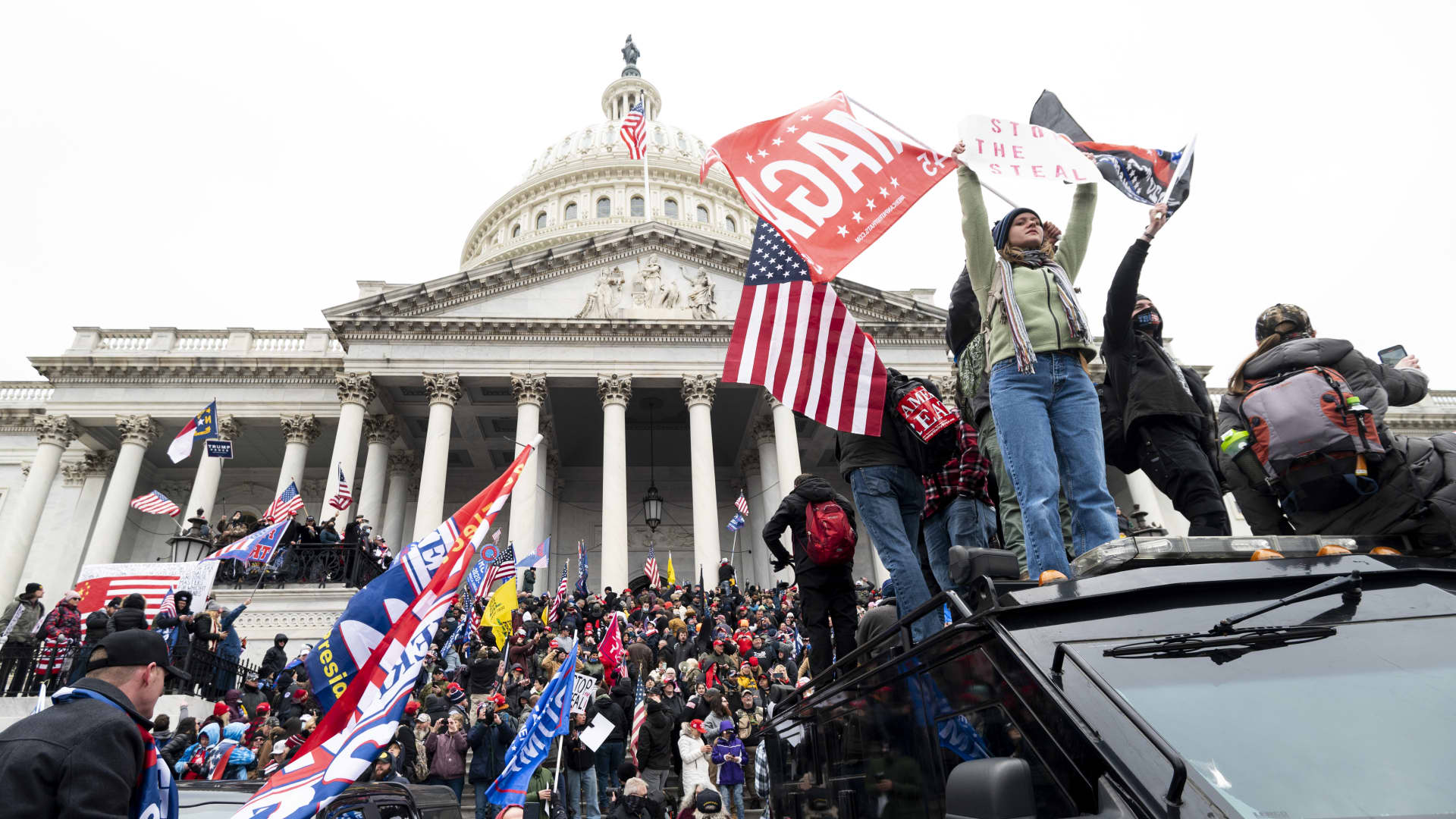 Trump supporters stand on the U.S. Capitol Police armored vehicle as others take over the steps of the Capitol on Wednesday, Jan. 6, 2021, as the Congress works to certify the electoral college votes.