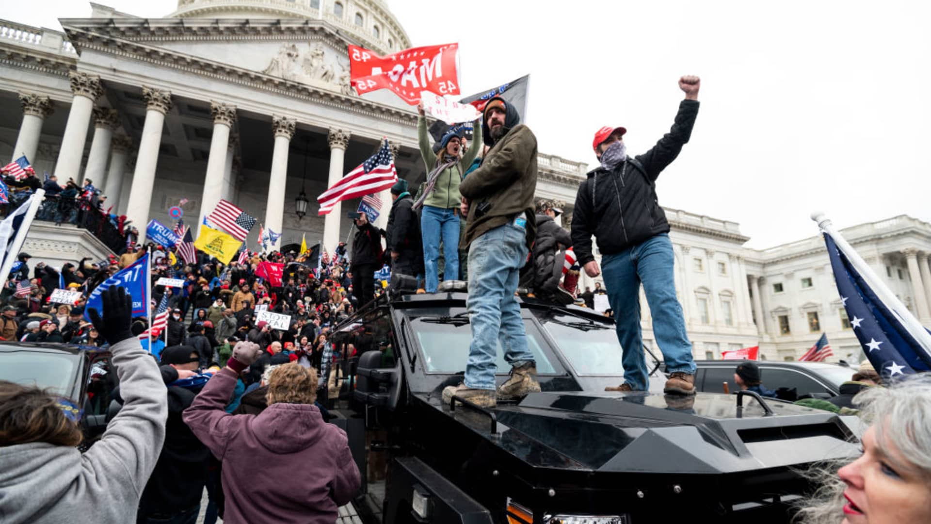 Trump supporters stand on the U.S. Capitol Police armored vehicle as others take over the steps of the Capitol on Wednesday, Jan. 6, 2021, as the Congress works to certify the electoral college votes.