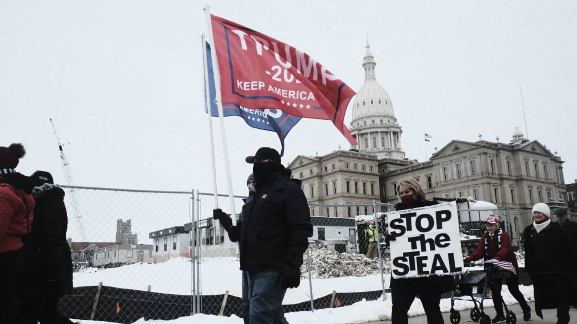 Donald Trump Supporters march around the Michigan State Capitol Building to protest the certification of Joe Biden as the next president of the United States on January 6, 2021 in Lansing, Michigan.