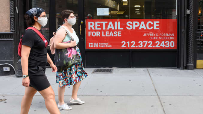 People walk by a sign displayed outside a retail space for lease as the city continues Phase 4 of re-opening following restrictions imposed to slow the spread of coronavirus on August 26, 2020 in New York City.