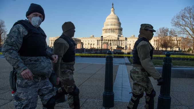 Members of the DC National Guard walk past the US Capitol in Washington, DC, on January 7, 2020, one day after supporters of outgoing President Donald Trump stormed the building.