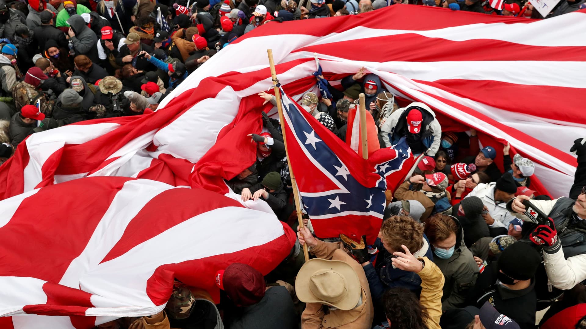 Protesters wave American and Confederate flags during clashes with Capitol police at a rally to contest the certification of the 2020 U.S. presidential election results by the U.S. Congress, at the U.S. Capitol Building in Washington, January 6, 2021.