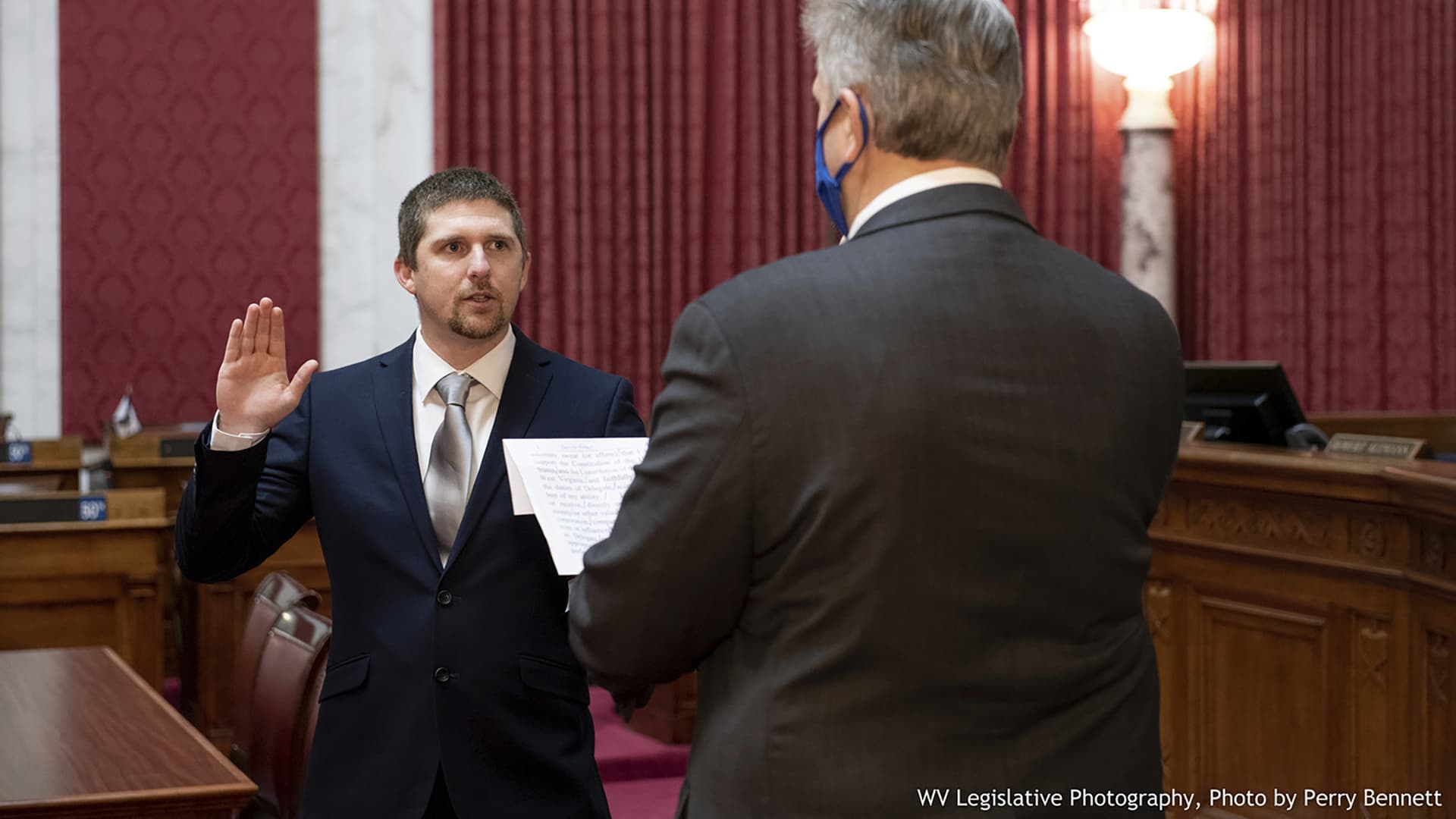 West Virginia House of Delegates member Derrick Evans, left, is given the oath of office Dec. 14, 2020, in the House chamber at the state Capitol in Charleston, W.Va.