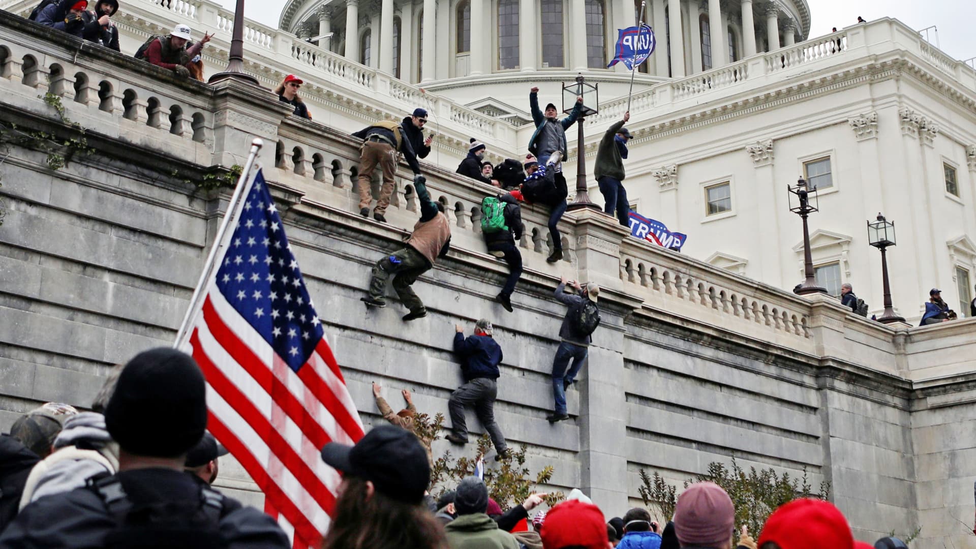 Supporters of U.S. President Donald Trump climb a wall during a protest against the certification of the 2020 presidential election results by the Congress, at the Capitol in Washington, January 6, 2021.