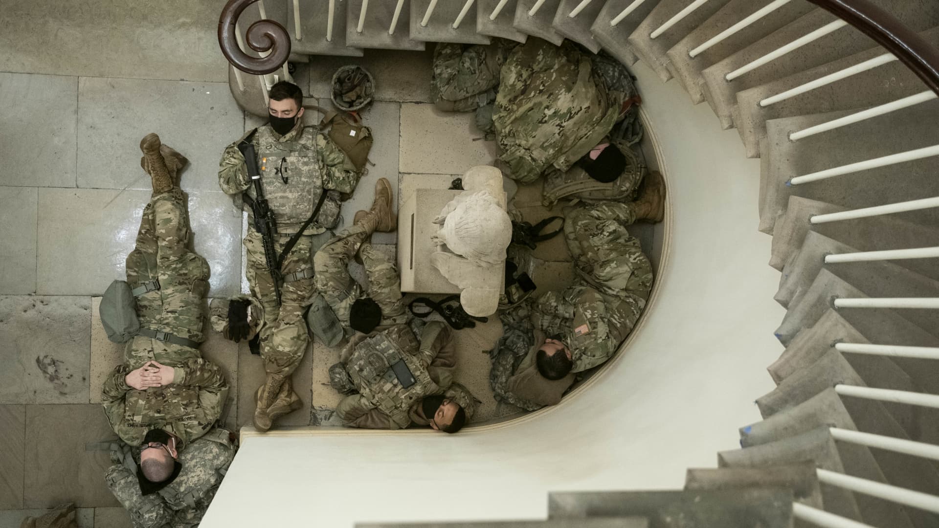 Members of the National Guard rest in a hallway of the U.S. Capitol building in Washington, D.C., U.S., on Wednesday, Jan. 13, 2021.