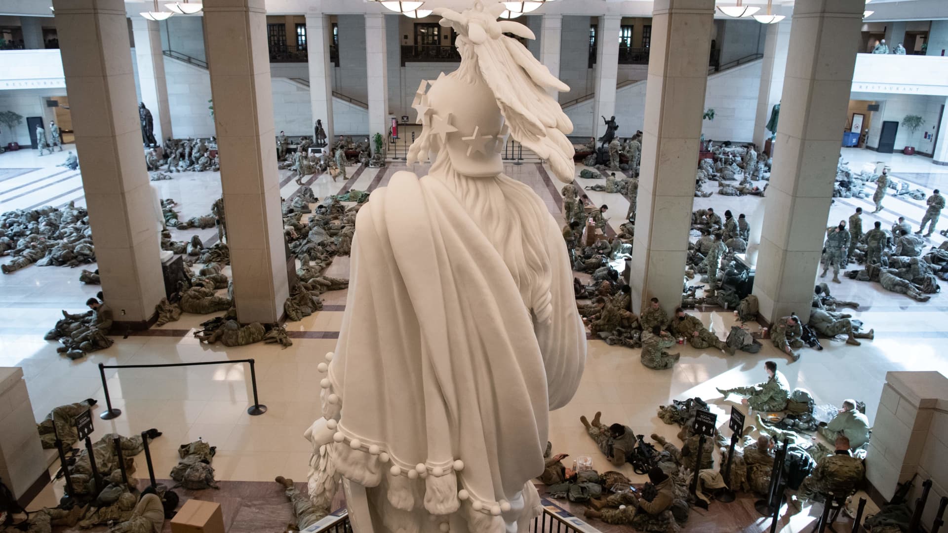 Members of the National Guard rest in the Capitol Visitors Center on Capitol Hill in Washington, DC, January 13, 2021, ahead of an expected House vote impeaching US President Donald Trump.