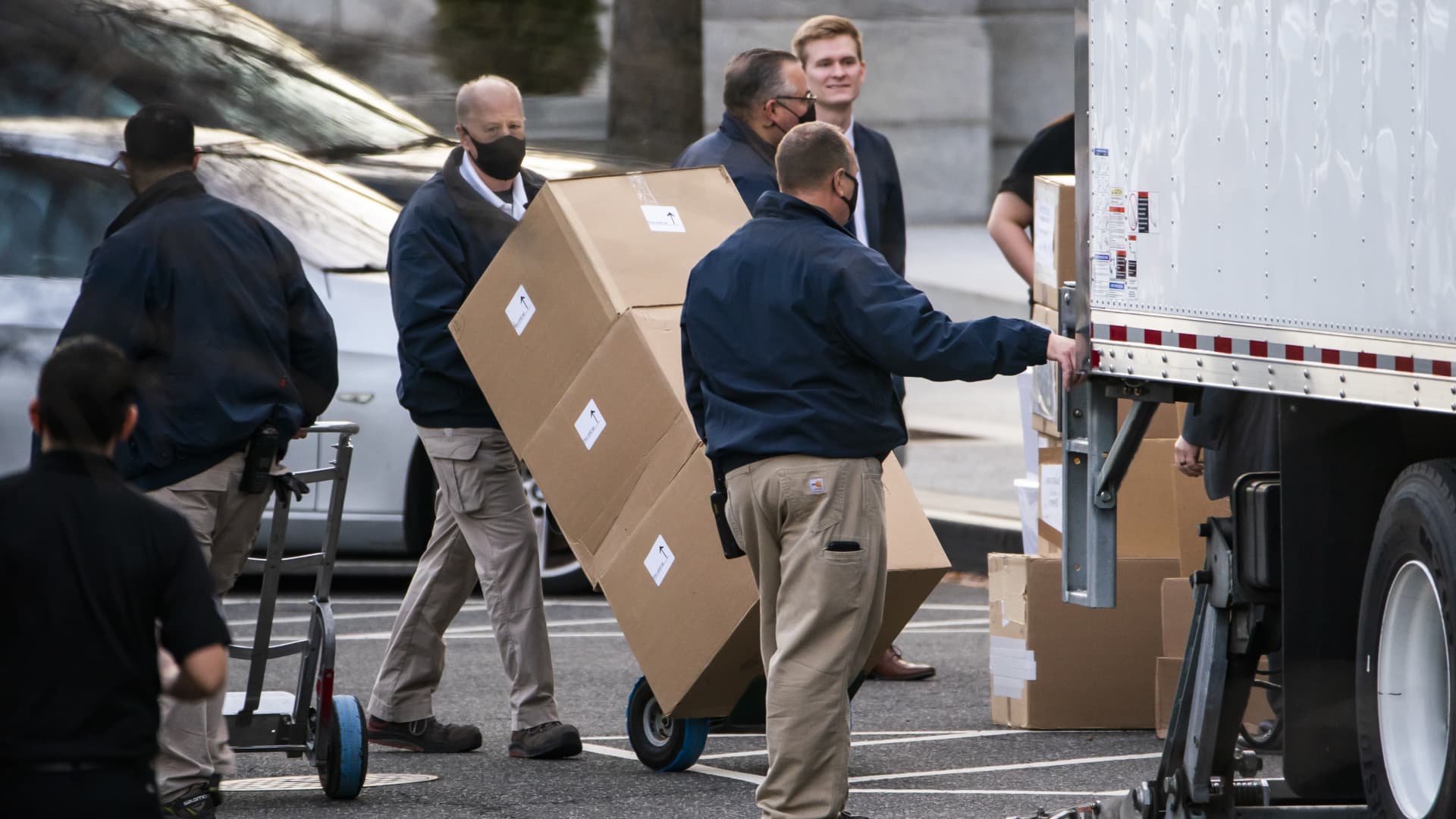 Workers move boxes onto a truck on West Executive Avenue between the White House and the Eisenhower Executive Office Building in Washington, D.C., on Thursday, Jan. 14, 2021.