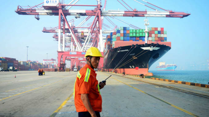 Un trabajador chino observa cómo se carga un barco de carga en un puerto en Qingdao, provincia de Shandong, en el este de China.