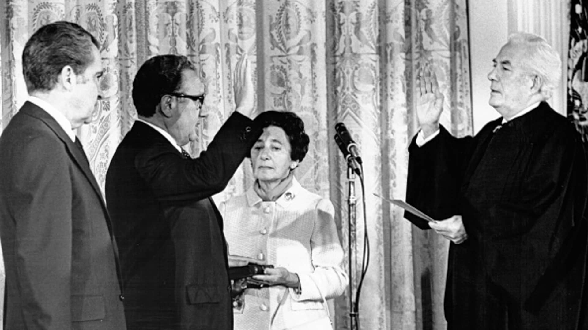 As President Richard Nixon watches, Henry Kissinger is sworn in as secretary of State by Chief Justice Warren Burger, September 1973. Kissinger's mother, Paula, holds the Bible.