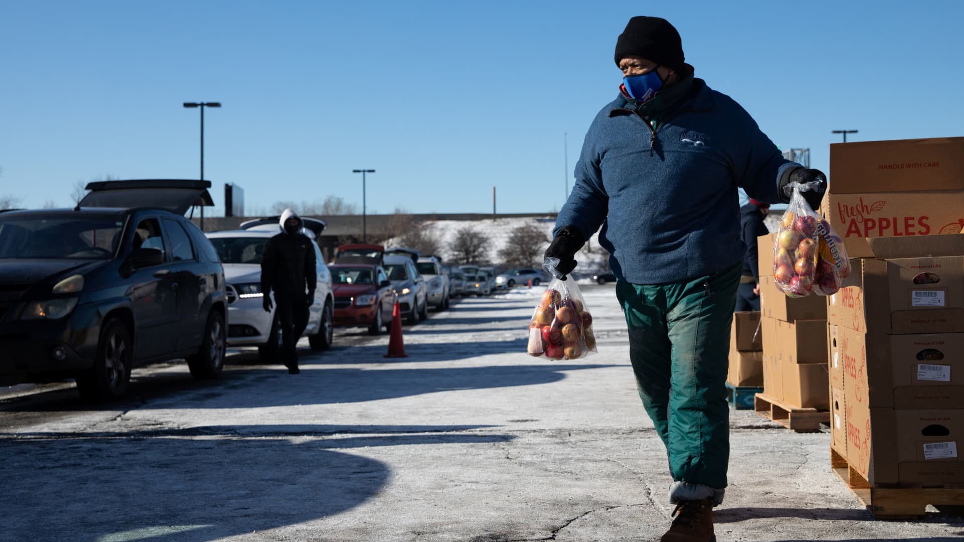 A volunteer carries food as he loads up cars of people who line up to receive food assistance amid the coronavirus disease (COVID-19) outbreak in Wayne County area at Second Ebenezer Church in Detroit, Michigan, January 29, 2021.