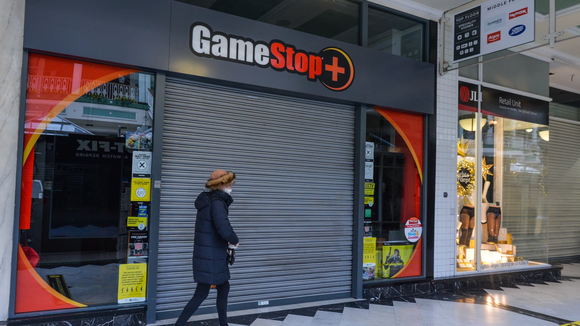 A woman walks by a closed GameStop shop in Stephen's Green Shopping Centre in Dublin.