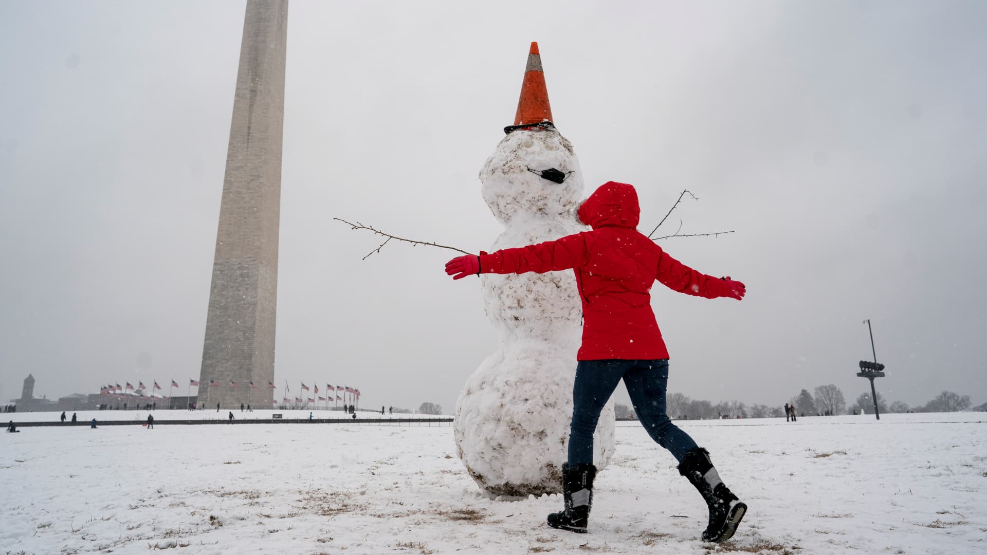 People play in the snow at the National Mall near the Washington Monument in Washington D.C., Jan. 31, 2021.