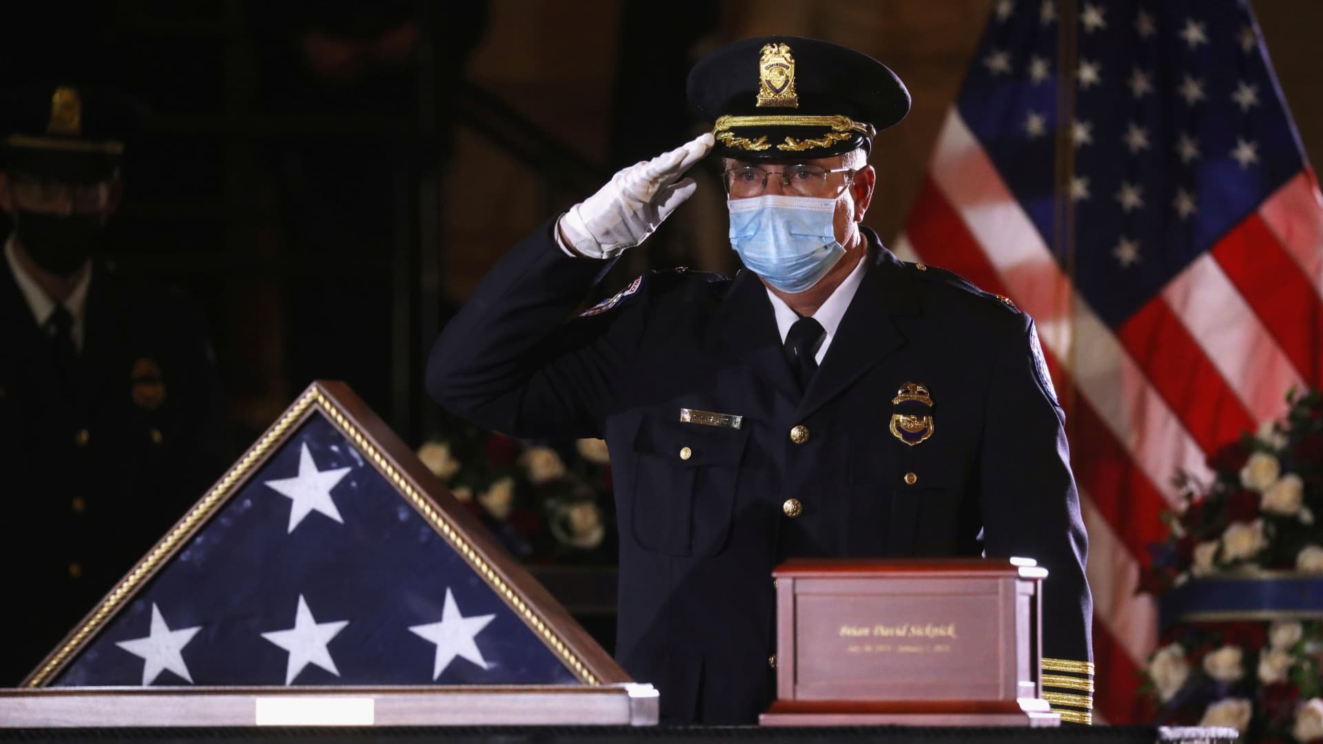 A U.S. Capitol Police Officer pays his respects to fellow officer Brian Sicknick, who died on January 7 from injuries he sustained while protecting the U.S. Capitol during the January 6 attack on the building, as he lies in honor in the Capitol Rotunda at the U.S. Capitol in Washington, U.S., February 2, 2021.