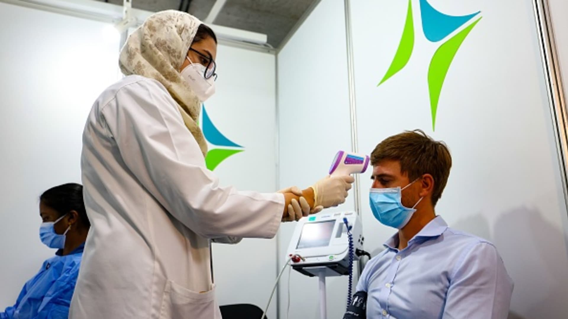 A health worker checks a man's temperature before receiving a dose of vaccine against the coronavirus at a vaccination center set up at the Dubai International Financial Center in the Gulf emirate of Dubai, on February 3, 2021. The United Arab Emirates has suffered a spike in cases after the holiday period.