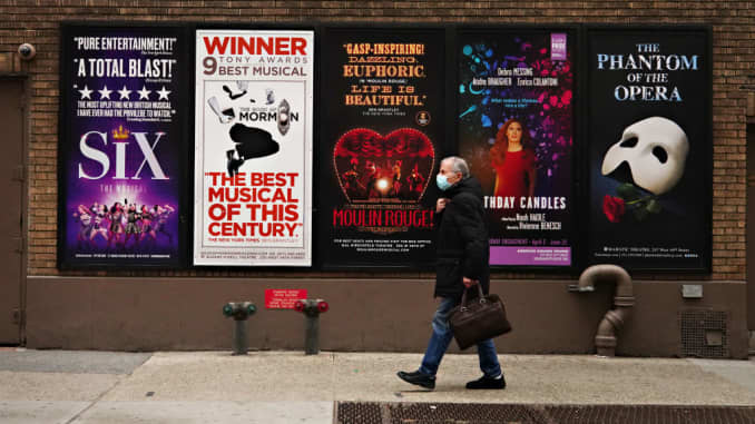 A person walks by Broadway posters near Times Square as theaters remain closed following restrictions imposed to slow the spread of coronavirus on January 15, 2021 in New York City.