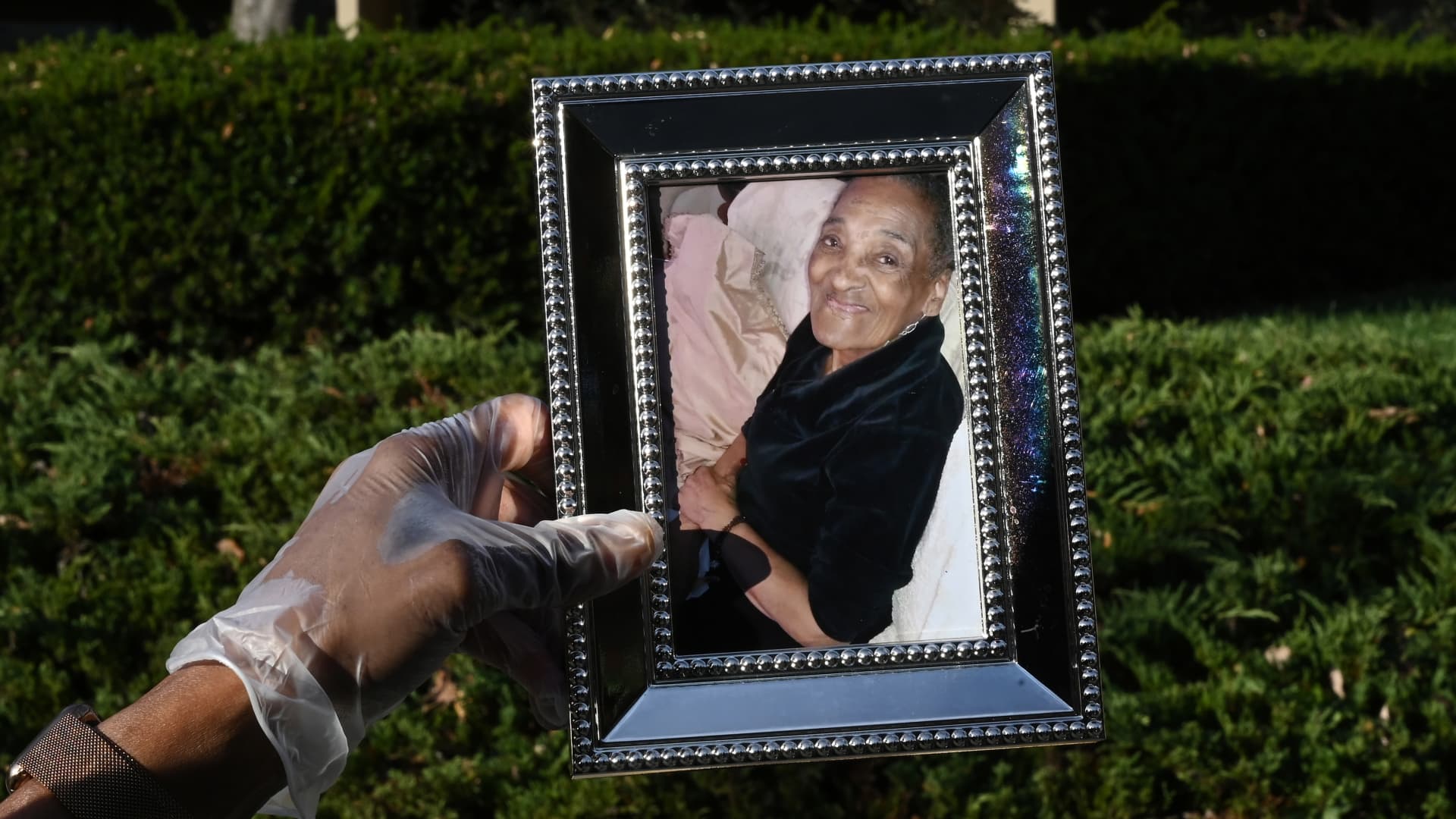 Derede McAlpin holds a photo of her mother, 92-year-old Sara McAlpin, who was diagnosed with Covid-19 in Rockville, MD.